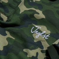 Close up of Jnglst Clothing logo on Green Polo