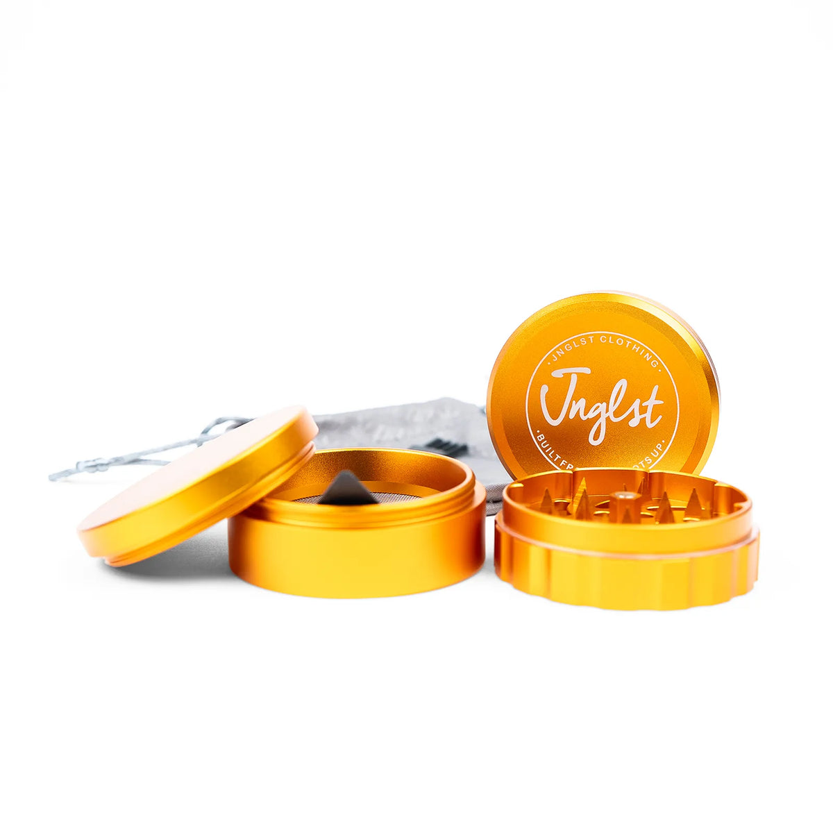 An orange-yellow metal herb grinder with its lid and components displayed on a clean white background. The brand name 'Jnglst' is printed on the lid.