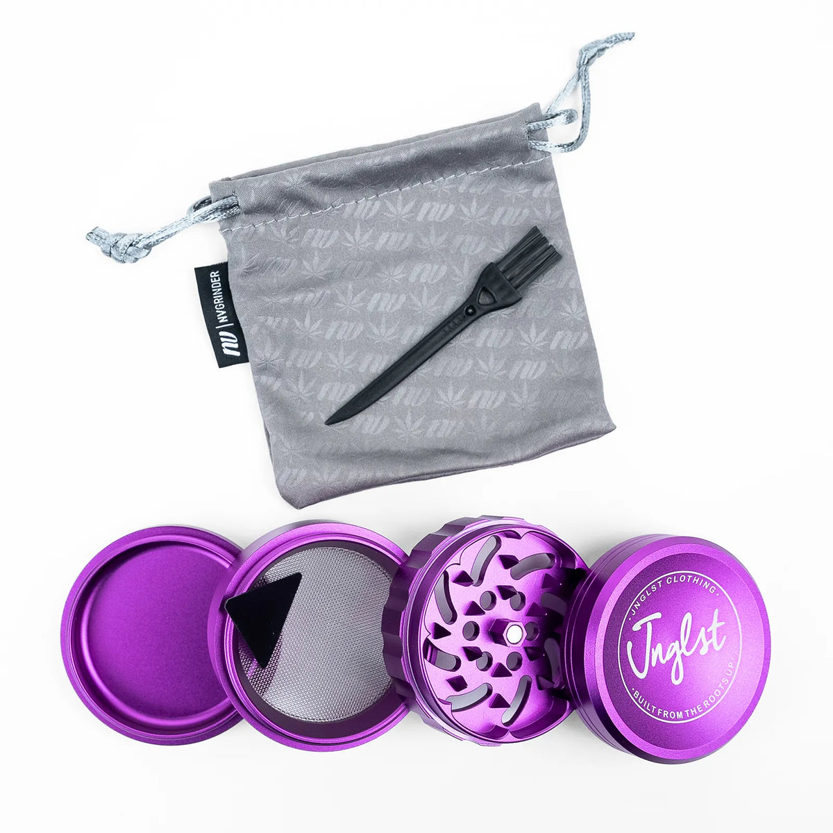 A purple metal herb grinder shown open with its inner components, alongside a gray drawstring pouch and a black spoon, on a white background. The pouch has a subtle cannabis leaf pattern, and the grinder lid features the brand name 'Jagdst'.