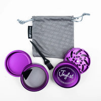 Purple metal herb grinder set with a gray drawstring bag, black cleaning brush, and mesh screen, arranged on a white background. The front lid shows the brand name 'Jnglst'.