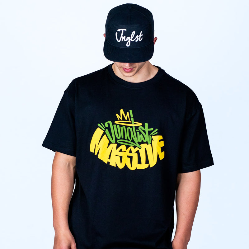 Person wearing a black t-shirt with colorful text and a black cap with 'Jnglst' on a light gray background