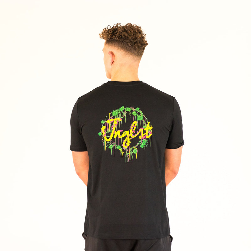 Model wearing a black Junglist t-shirt with colourful text and graphics on the back, standing against a white background.