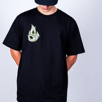 Person wearing a black t-shirt with a green logo on a plain background