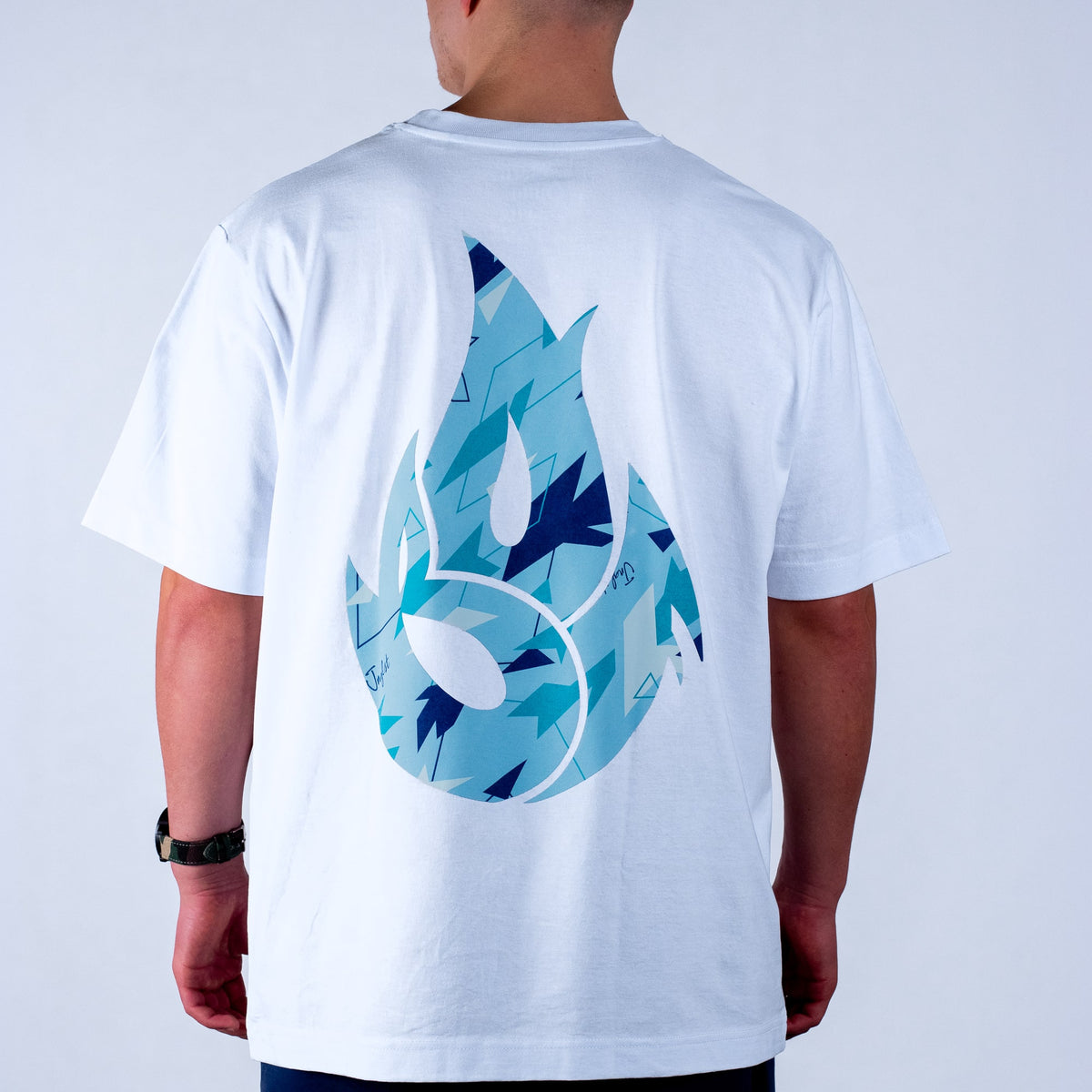 White Born Outta Fire t-shirt with blue and black abstract design on the back, worn by a person against a white background