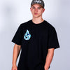 Person wearing a black Junglist t-shirt with a blue graphic design and a cap on a light gray background