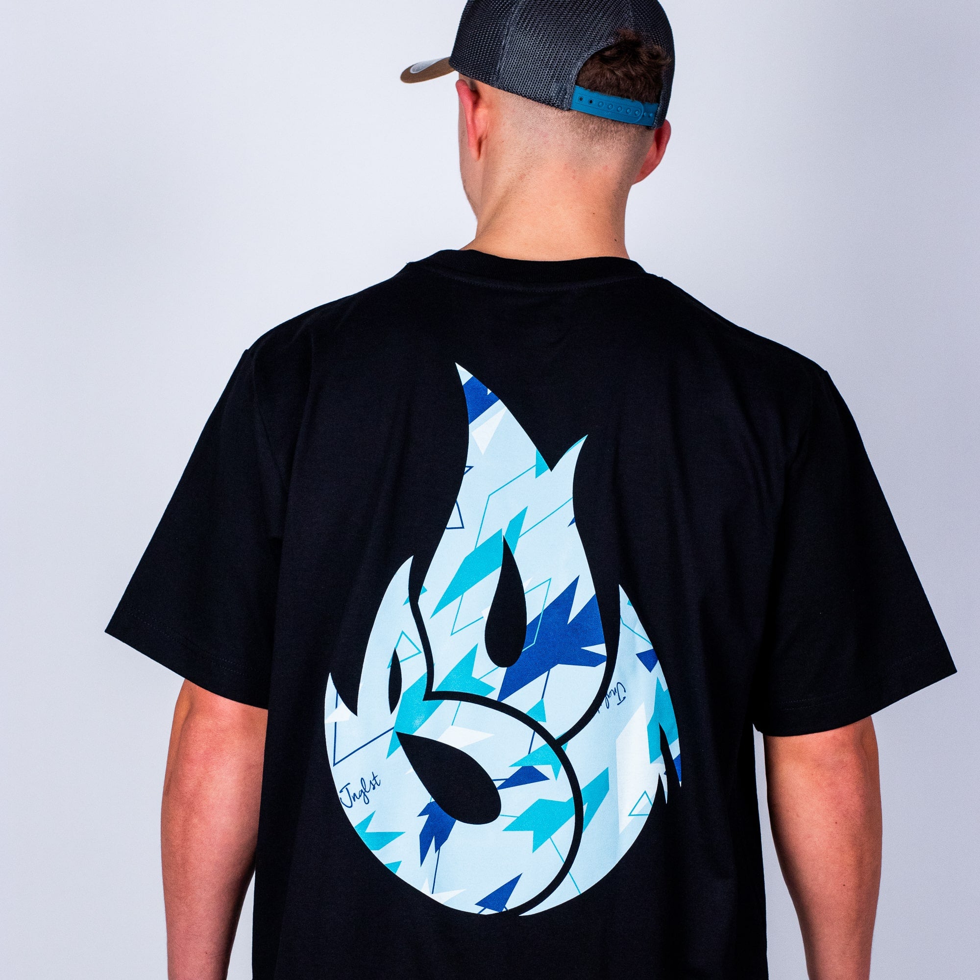 Person wearing a black t-shirt with a blue and white Born Outta Fire design on the back against a plain background