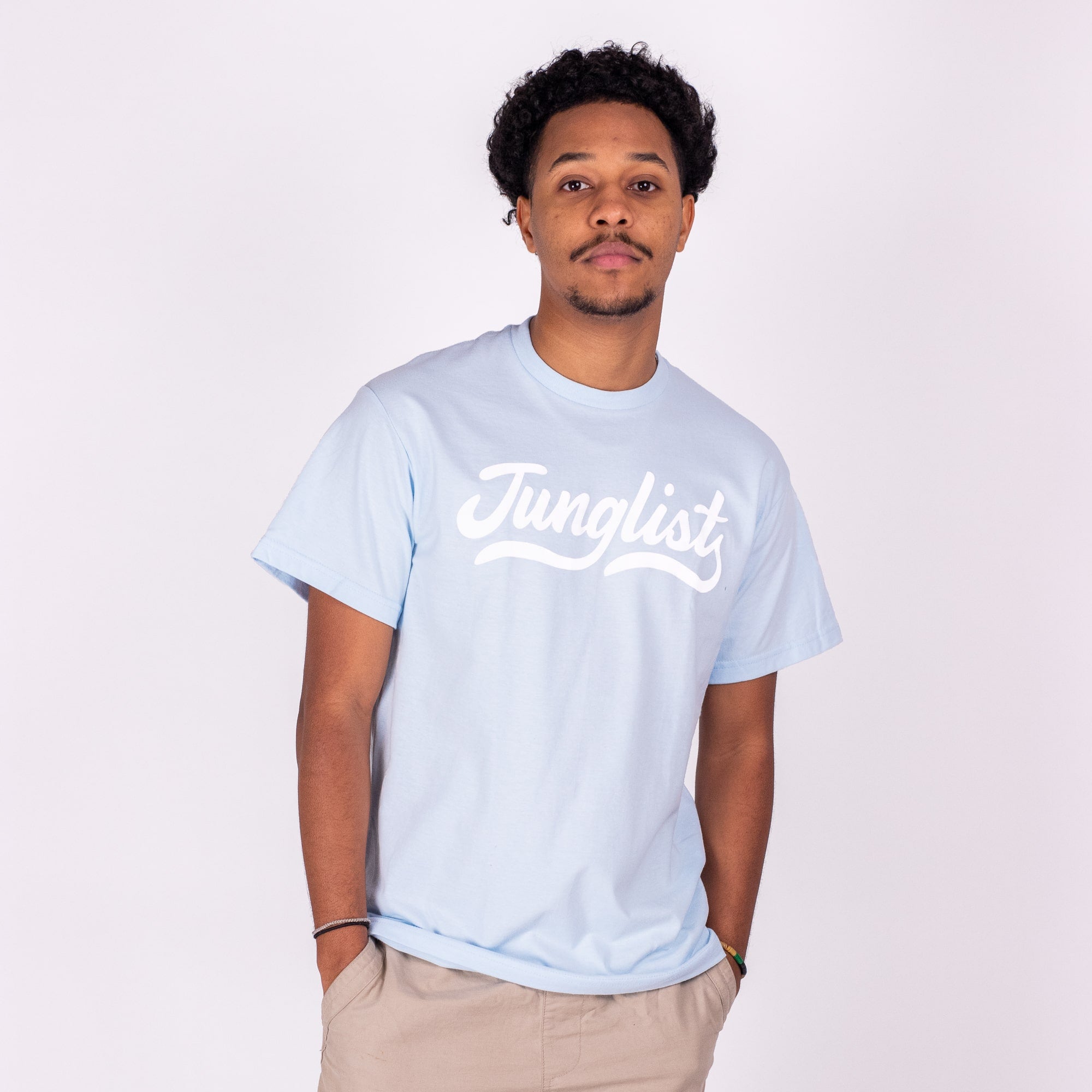 Person wearing a light blue t-shirt with 'Junglist' text on a white background