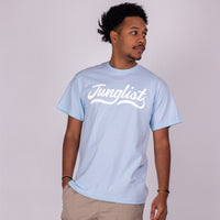 Person wearing a light blue t-shirt with 'Junglist' text on a plain background