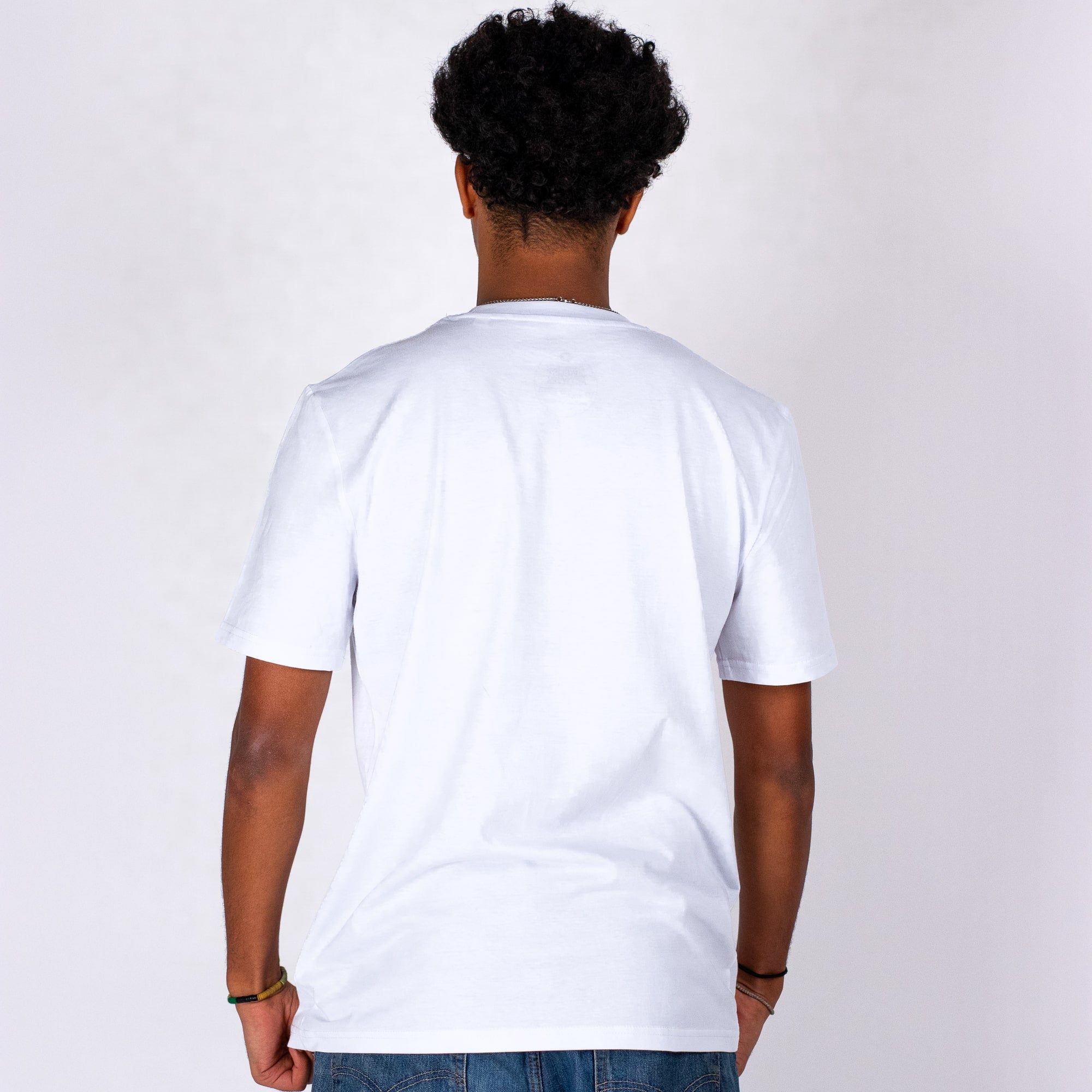 Person wearing a plain white t-shirt against a light gray background