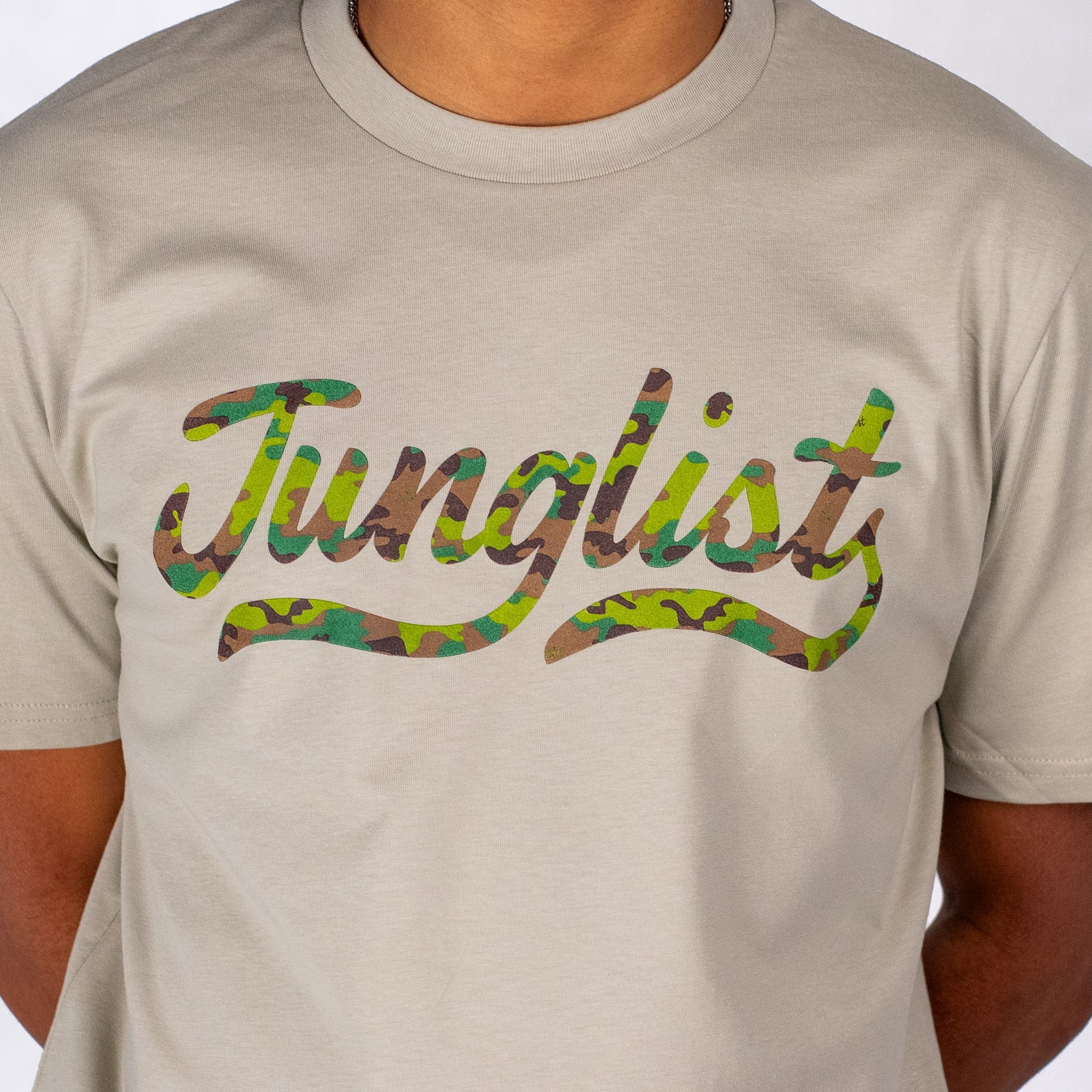 Beige t-shirt with 'Junglist' in colorful script on a plain background