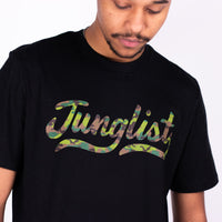Person wearing a black t-shirt with 'Junglist' in colorful script on a white background