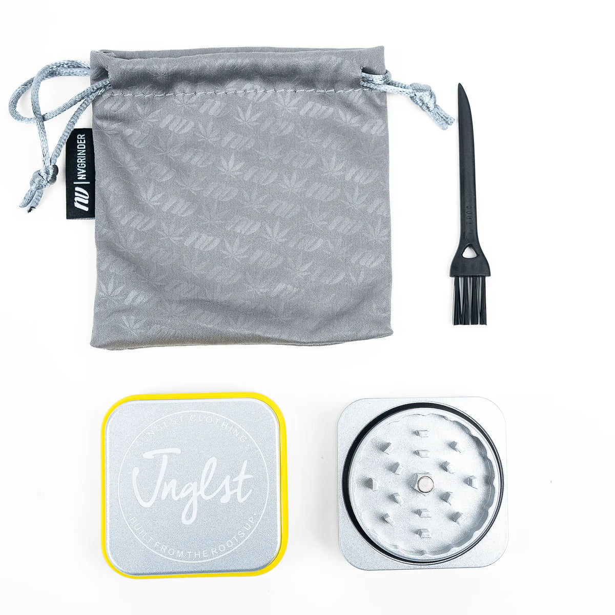 A Jnglst weed grinder kit on a white background, including a gray drawstring pouch with a subtle leaf pattern, a black cleaning brush, a silver metal grinder with a black ring, and a silver lid with a yellow border and the Jnglst logo.