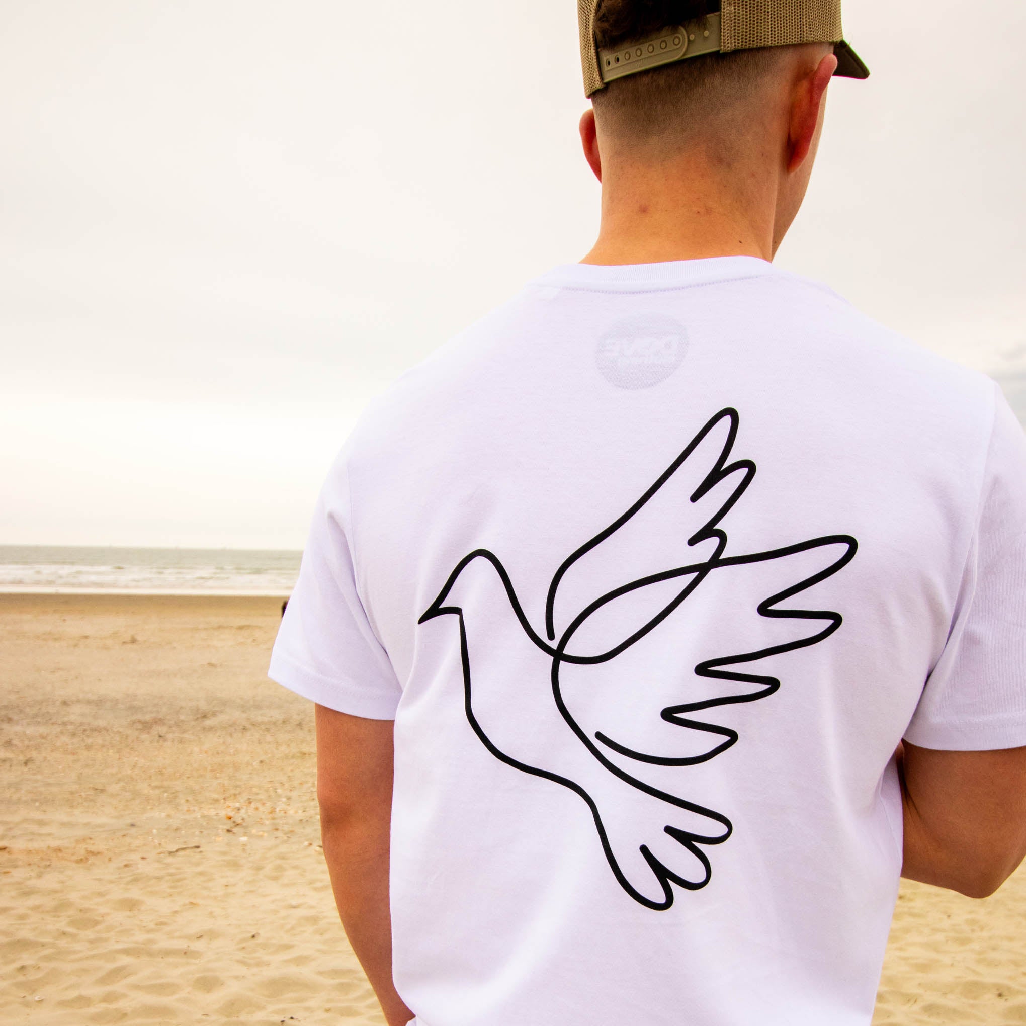 White Dove Clothing T-Shirt worn by raver at the beach