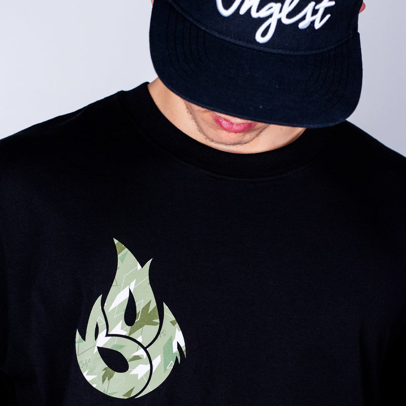Person wearing a black t-shirt with a green logo and a dark cap with white text.