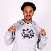 Person wearing a gray hoodie with 'JNGLST' logo on a white background