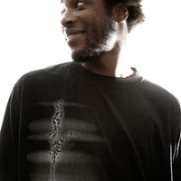 Man wearing a black long-sleeve shirt with a design on a white background