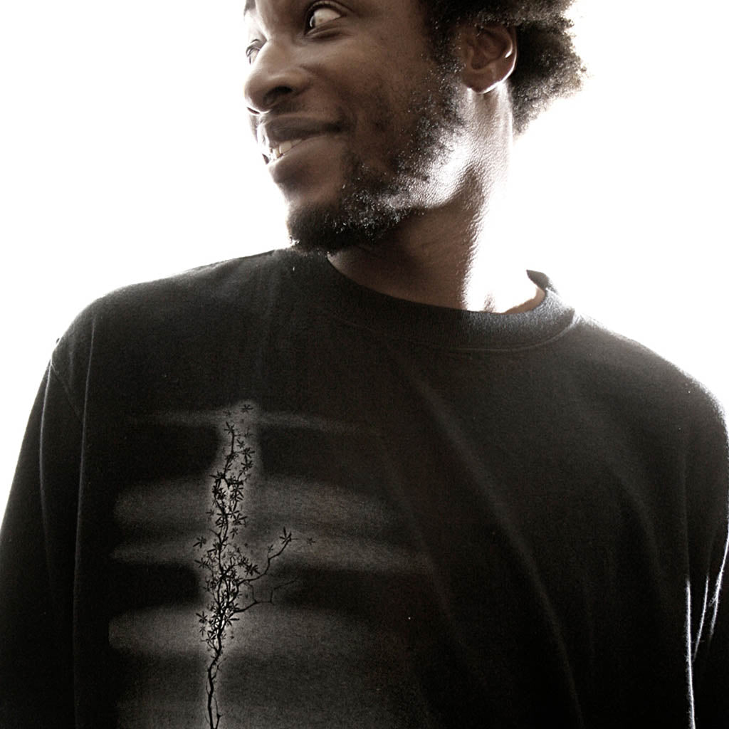 Man wearing a black long-sleeve shirt with a design on a white background