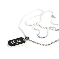 A silver-toned chain necklace with a rectangular black pendant engraved with the name 'Jnglst' in white script, shown on a clean white background.