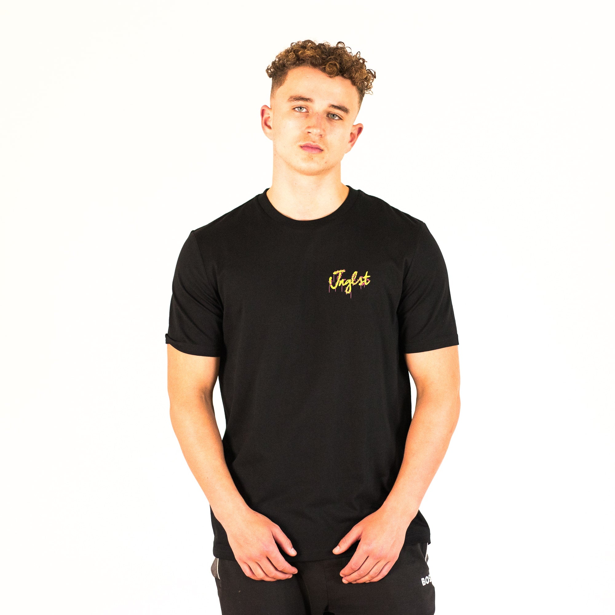Person wearing a black Junglist t-shirt with yellow text on a white background