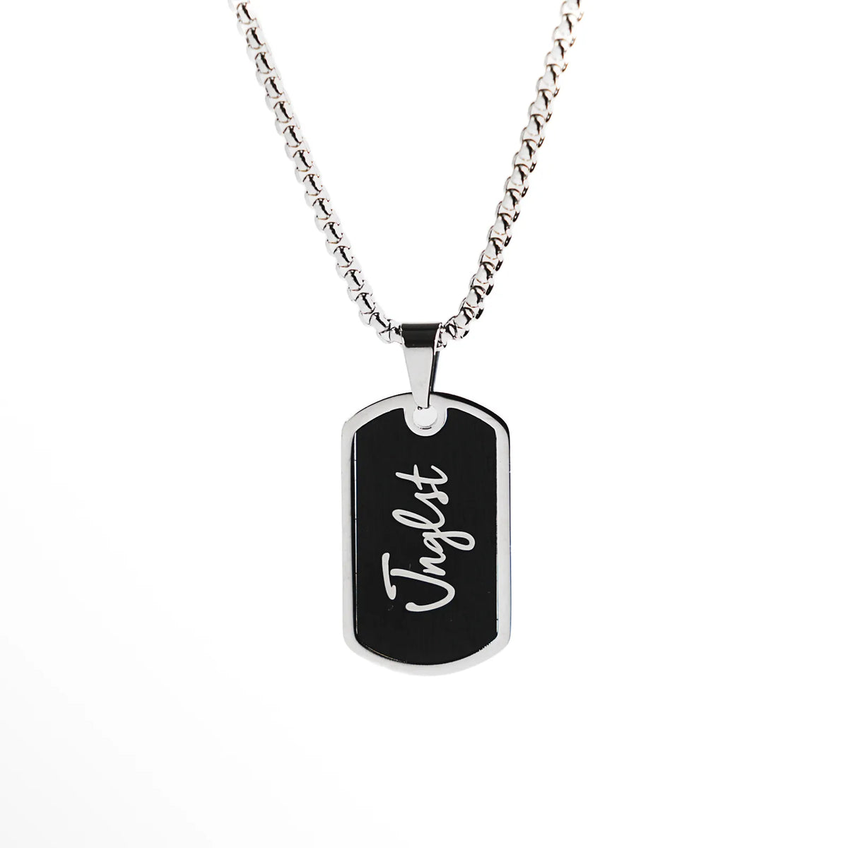 A silver-toned dog tag necklace with a black enamel insert and the name 'Jnglst' in white script, suspended from a silver box chain against a plain white background.