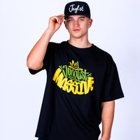 Person wearing a black Junglist Massive t-shirt with colorful text and a black cap with white text on a light grey background