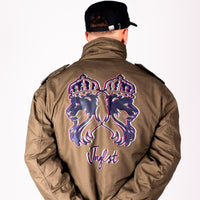 Person wearing a brown jacket with a purple and pink Jnglst Lion design on the back, on a white background