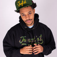 Person wearing a black hoodie and green cap with 'Junglist' text on a white background