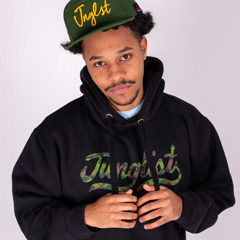Person wearing a black hoodie and green cap with 'Junglist' text on a white background