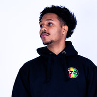 Person wearing a black hoodie with a colorful logo on a white background