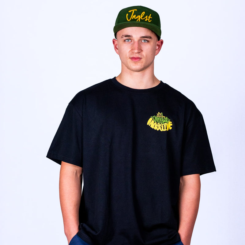 Person wearing a black t-shirt with yellow text and a green cap with yellow text on a white background
