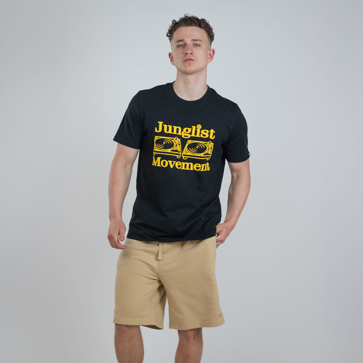 Person wearing a black junglist movement t-shirt with yellow text and graphics
