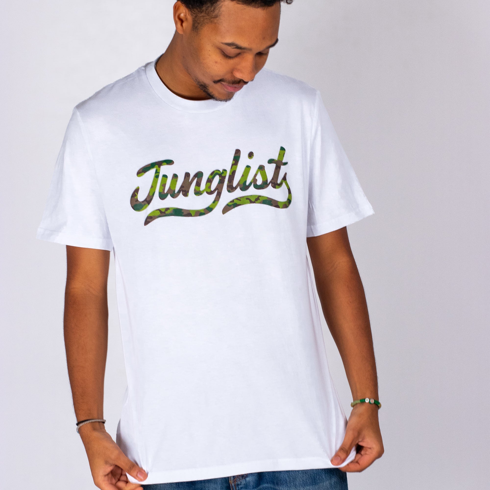 Man wearing a white t-shirt with 'Junglist' printed in green on a plain background
