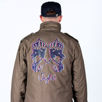 Person wearing a brown M65 jacket with a colorful graphic design on the back, on a white background