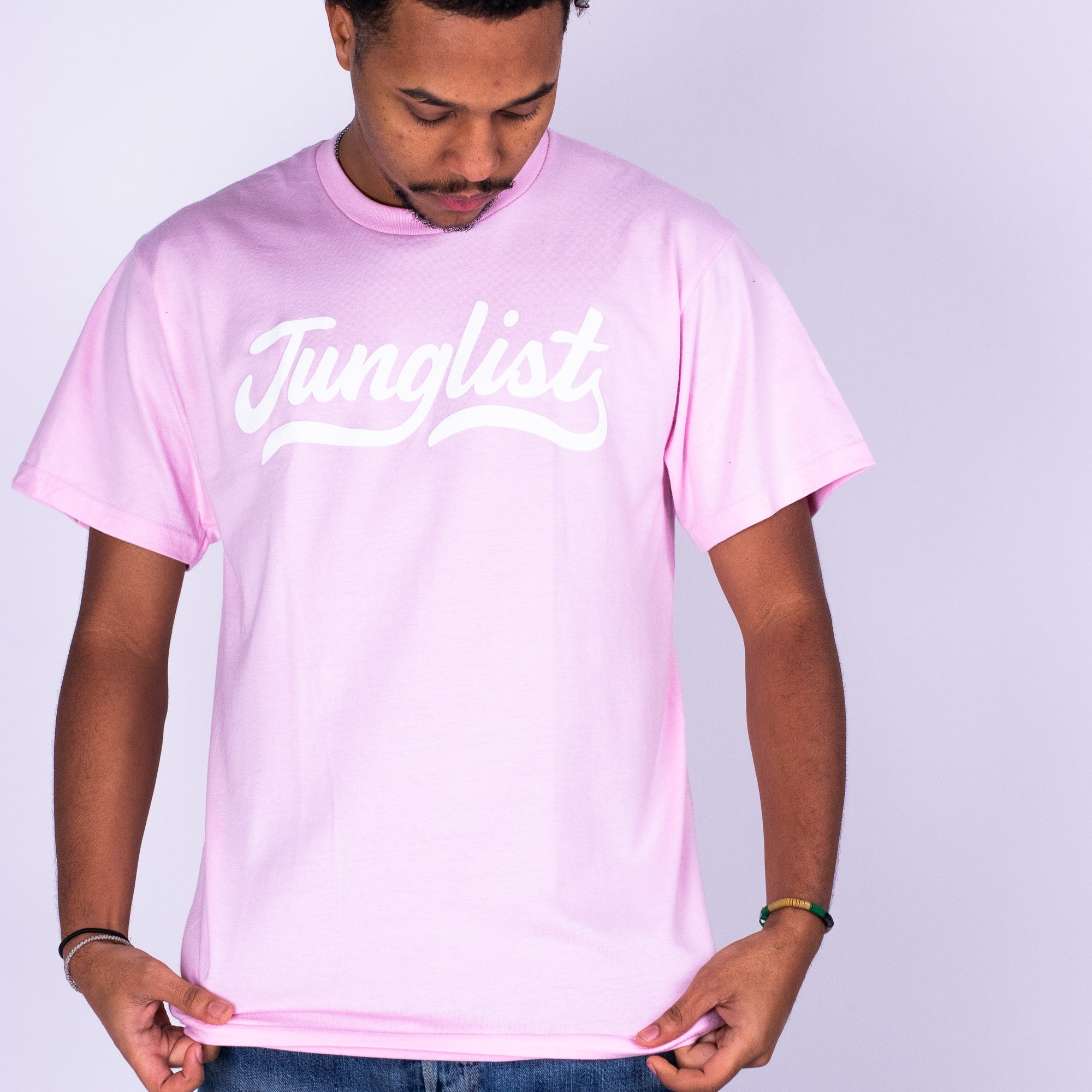 Person wearing a pink t-shirt with 'Junglist' text on a light gray background
