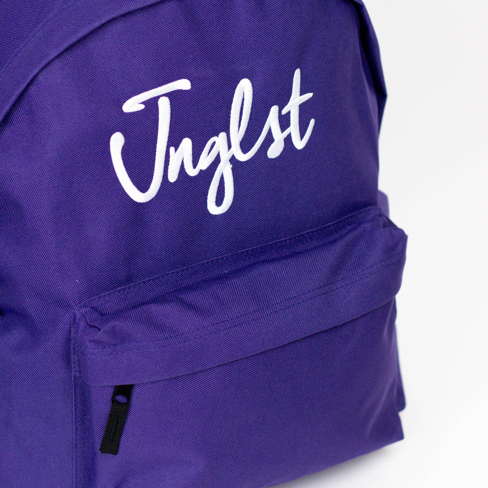 Purple backpack with 'Jnglst' text on a white background