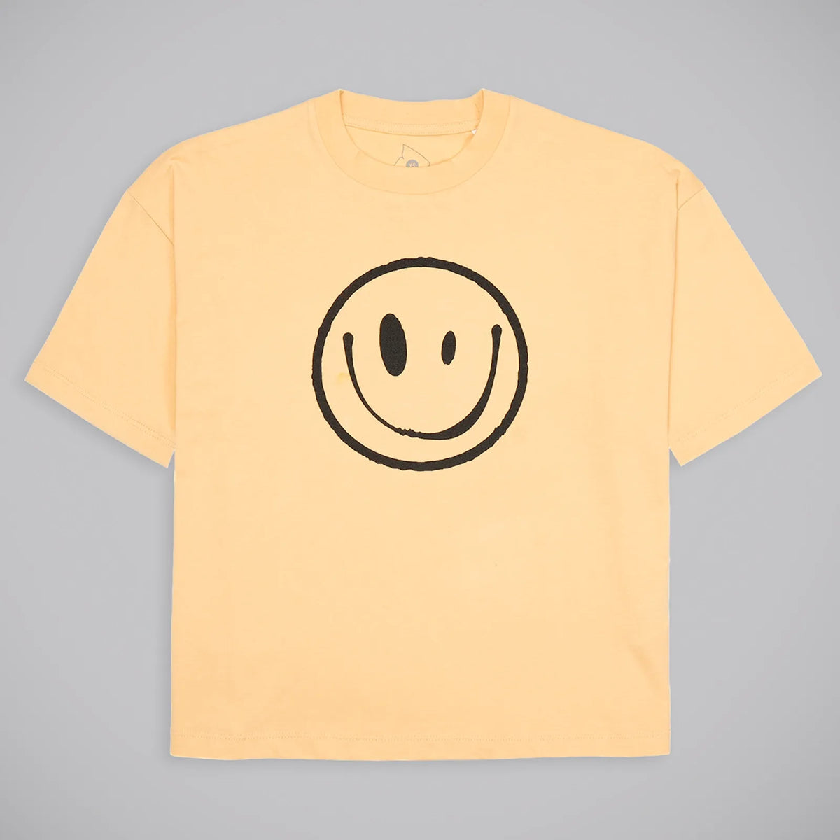 A pale yellow short-sleeve crewneck t-shirt featuring a large black hand-drawn smiley face graphic on the chest, displayed flat against a neutral gray background.