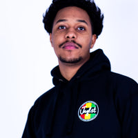 Person wearing a black hoodie with a colorful logo on a white background