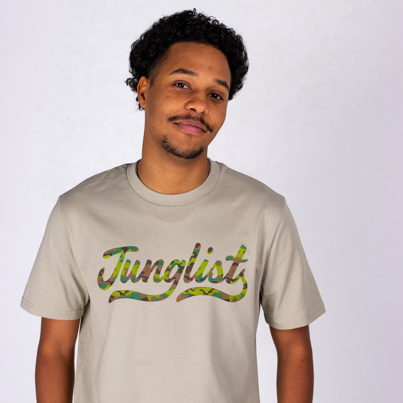 Person wearing a beige t-shirt with 'Junglist' design on a white background