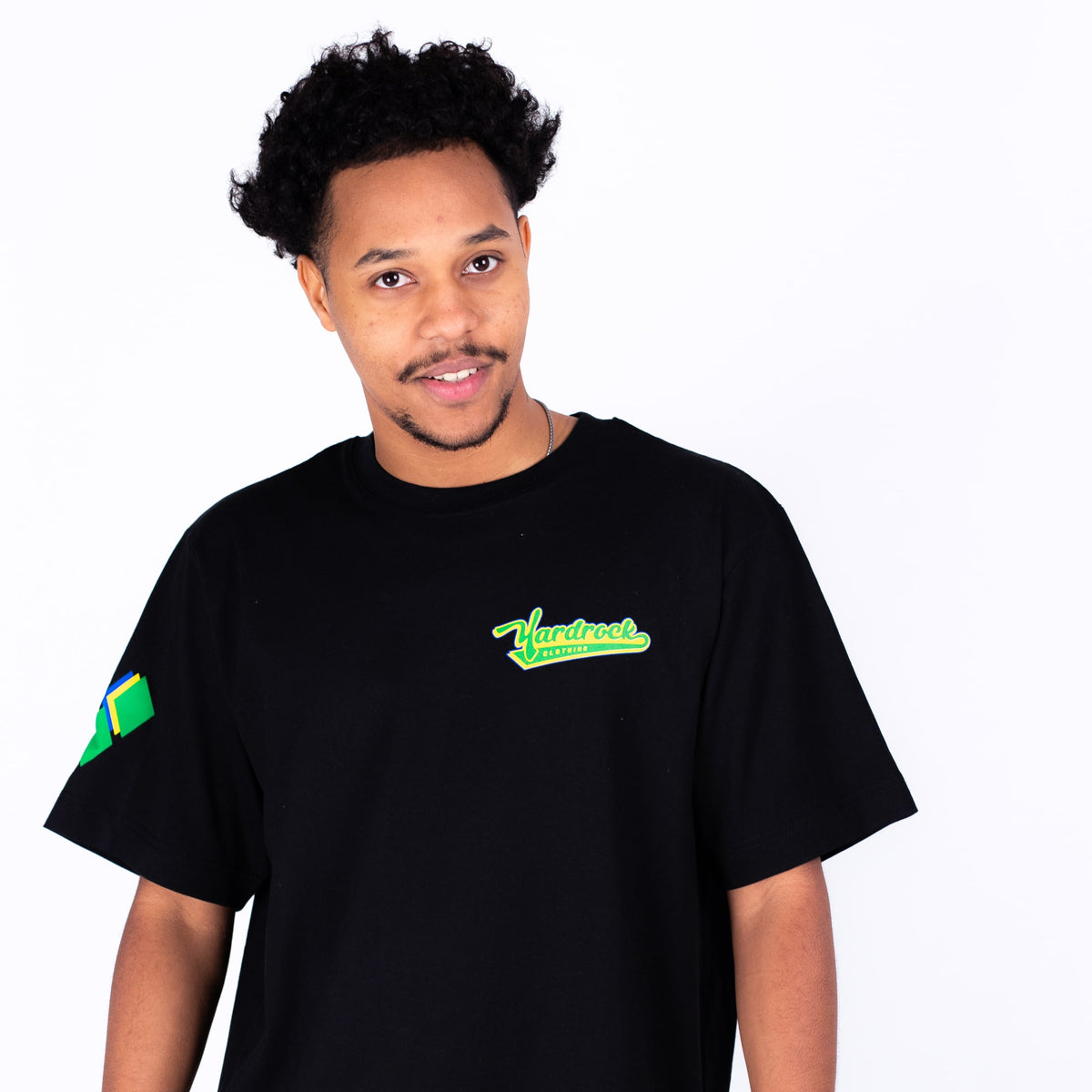 Person wearing a black t-shirt with green logo on a white background