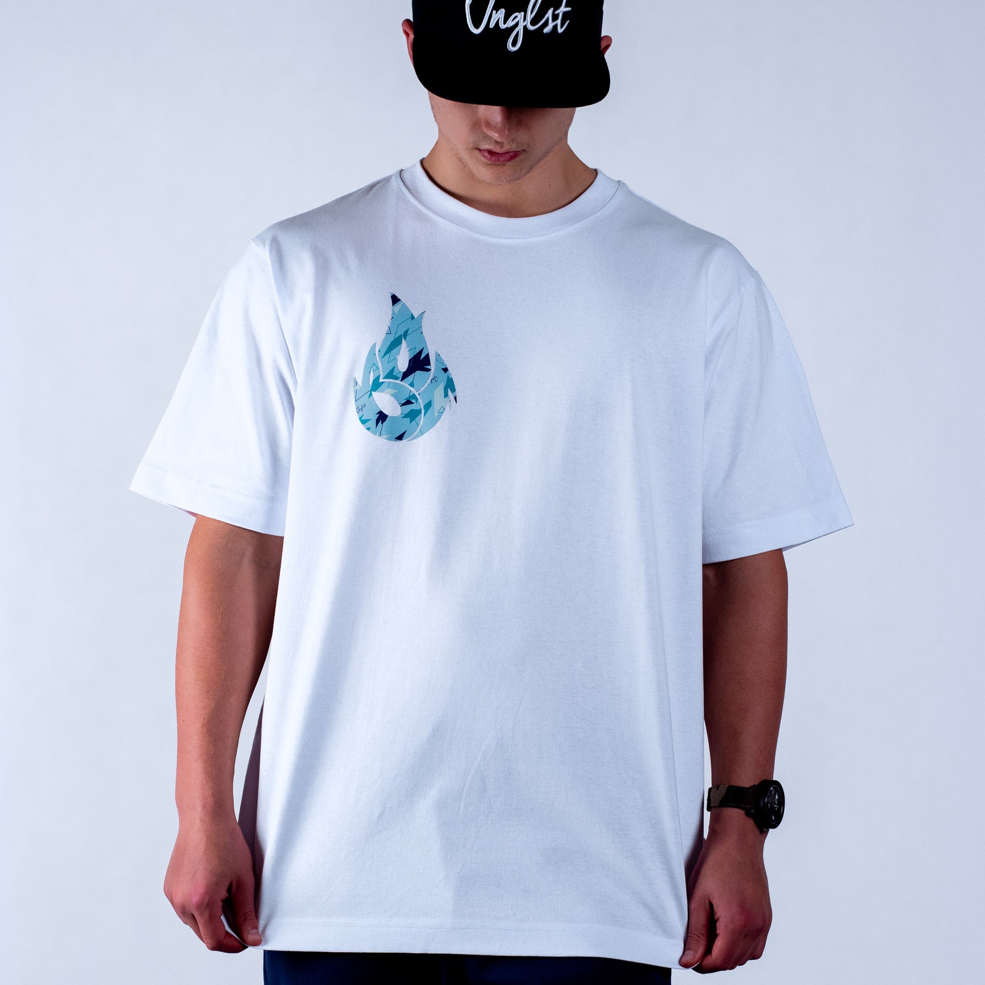 Person wearing a white t-shirt with a blue graphic design on a plain background