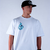 Person wearing a white Junglist t-shirt with a blue graphic design and a black cap on a light grey background