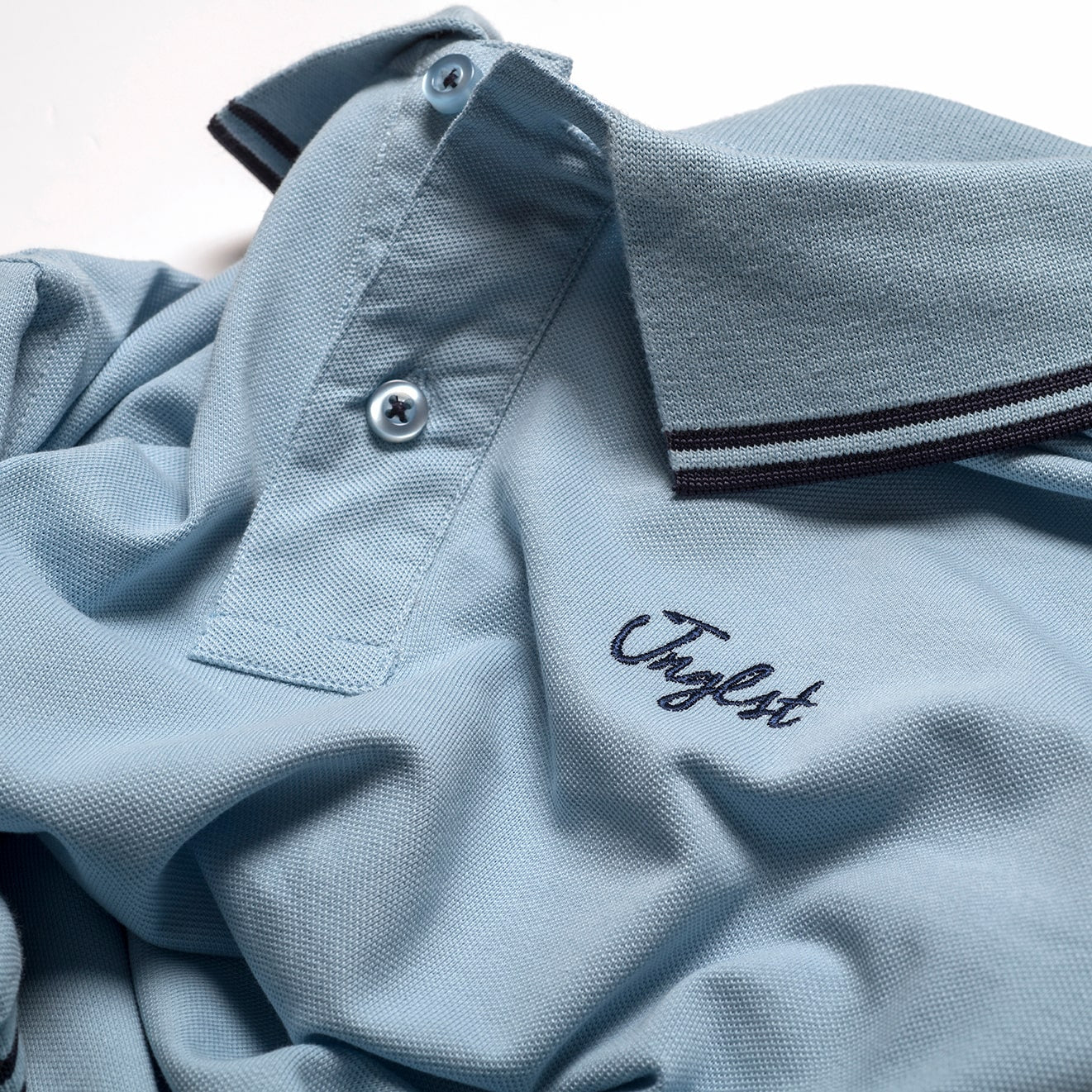 Close up of Jnglst Clothing logo on polo shirt